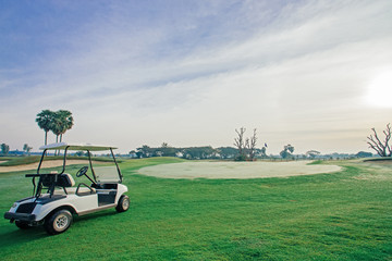 Golf buggy on beautiful green grass in golf course.