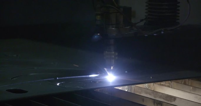 Rays of lights coming from the machine while making a pattern out of the metal sheet
