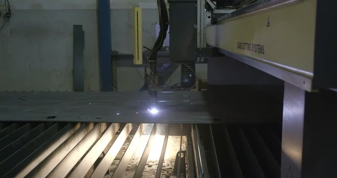 Ray of lights underneath the metal sheet coming from the metal milling machine that creates pattern on the metal sheet