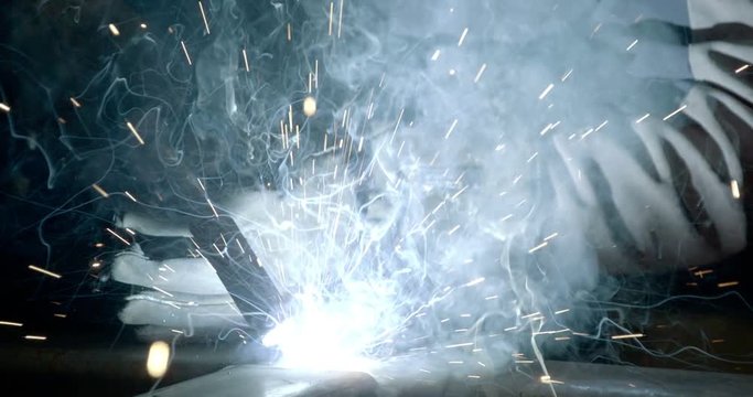 The light rays coming out from the welding machine inside the factory of steel