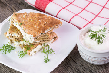  Stack of toasted and cut feta stuffed pita pocket with dill.