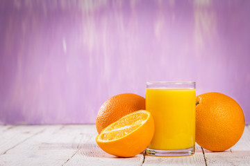 glass of juice and orange slices on a table