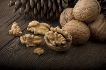 Walnut kernels and whole walnuts on rustic old wooden table