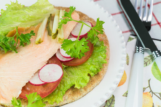 Fresh homemade pita sandwich with hot smoked salmon, letuce and vegetables.