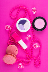 Summer Accessories and Cosmetics for rest on a pink background - sunglasses, lipstick, powder, colored beads, nail polish. View from above. Flat lay.