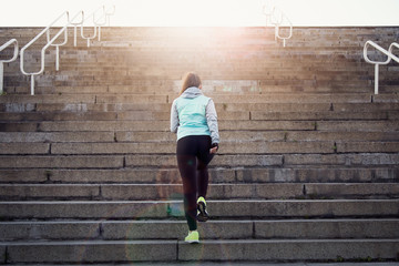 Sporty woman athlete working out running on stairs outdoors.