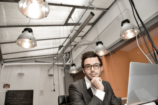 Portrait of smiling Businessman posing  in coworking office
