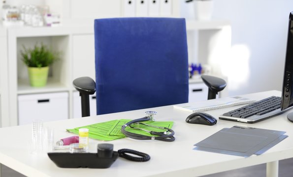 Leerer Stuhl in Arztpraxis am Schreibtisch