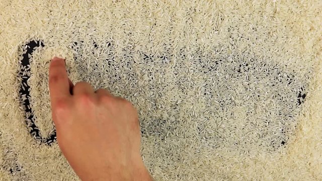 Men hand draws word organic on the surface of rice