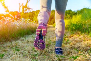 Woman running at sunset in a field