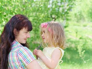 mother playing with her  little daughter on nature