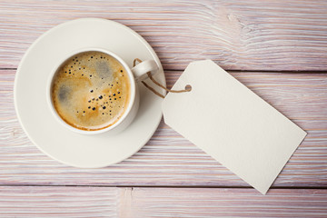 Top view of coffee cup and empty label over old wooden backgroun