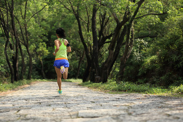 young fitness woman runner running in forest