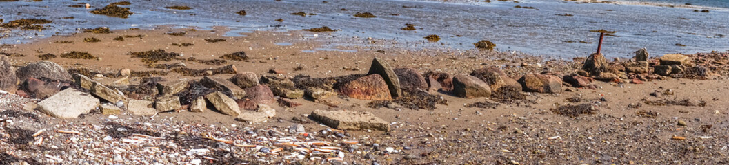Fototapeta na wymiar Pebbles on a beach in panorama