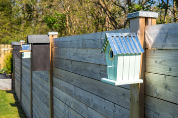 Bird houses on a row at a fence