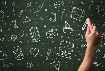Hand writing icons on blackboard
