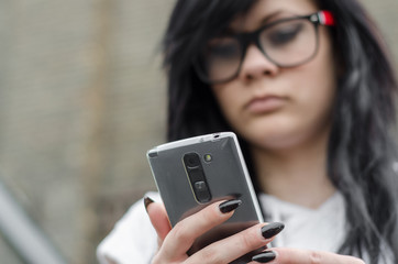 Emo girl reads message on mobile phone