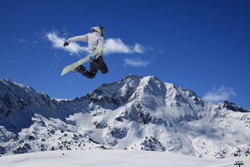 Fototapeta na wymiar Snowboard rider jumping on mountains. Extreme snowboard freeride sport.