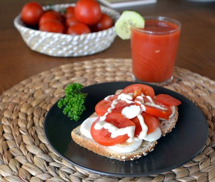 Fresh healthy sandwich with eggs and tomato on a plate and tomato smoothie