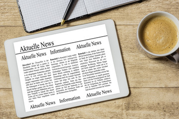 Tablet mit akuellen News auf einem Holztisch