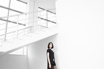 Portrait of black-haired woman in black looking at camera