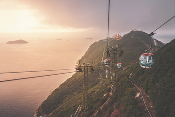 View of a cable car during beautiful sunset  in Hong Kong.  Mountain, sea or ocean landscape. Mountain covered with green forest. 