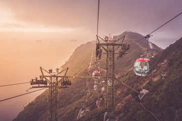 View of a cable car during beautiful sunset  in Hong Kong.  Mountain, sea or ocean landscape. Mountain covered with green forest.