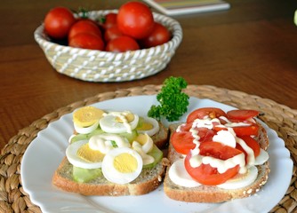 Fresh and tasty sandwich with eggs and cucumber on a plate on a table