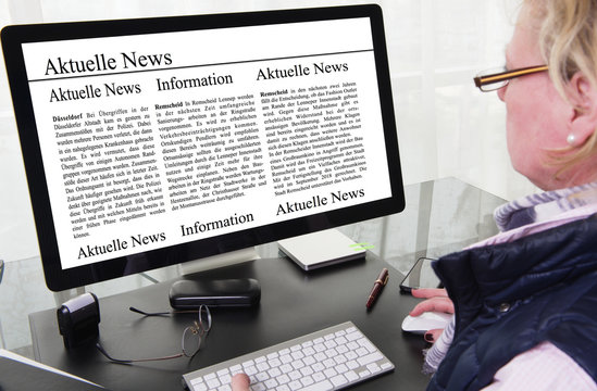 Frau liest Zeitungsartikel auf Computerbildschirm