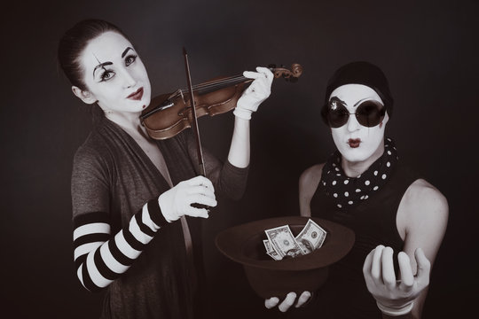 Two mimes playing a violin for the money