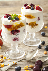 Yogurt with fruits on wooden table