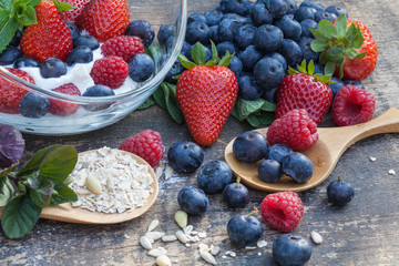Frühstück mit Quark, Haferflocken und Beeren auf altem Holztisch