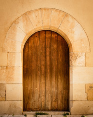 Ancient wooden door in stone wall.