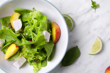 Spinach salad with fruit on marble. Spinach healthy salad