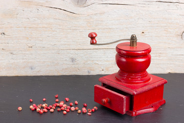 Vintage, red pepper mill with peppercorns