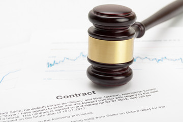 Wooden judge's gavel over contract - close up studio shot