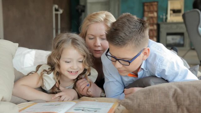 мама и старший брат помогают сделать домашнее задание младшей сестре