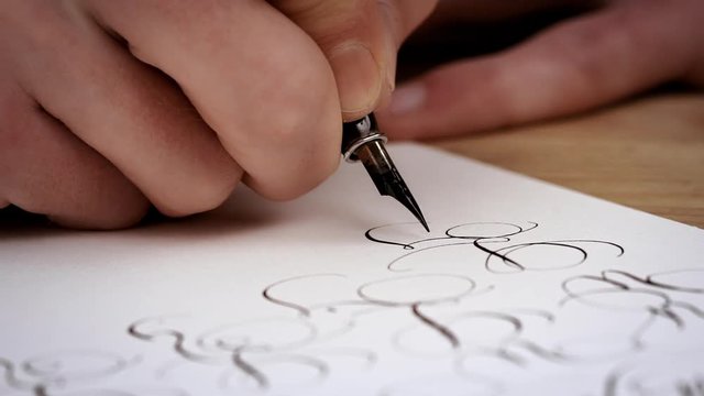 Writting letter with a pen. Calligraphy lesson. Close up. Slow motion