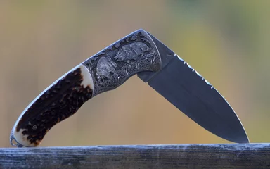 Foto op Canvas hunting pocket knife with wild boars engraving © Rionegro