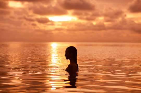 Female Going For A Swim At Sunset.