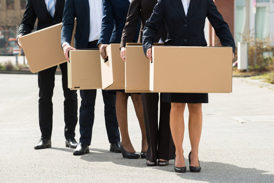 Businesspeople With Cardboard Boxes Standing In A Line