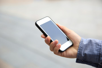 people hand with smart phone in modern city