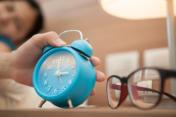 Close up of hand of girl turns off the alarm clock.