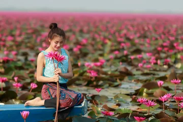 Fotobehang Lotusbloem Beautiful girl sitting in boat in the lotus field  © visoot