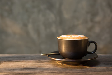 Hot cappuccino coffee cup on wooden table agent sunlight in morn