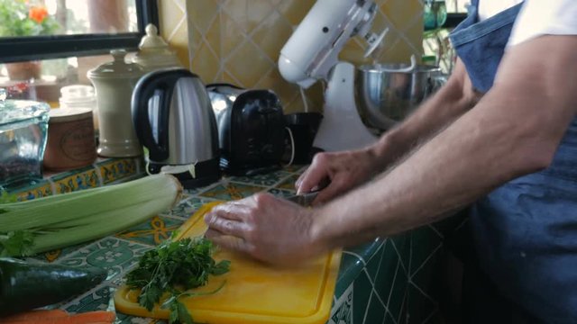 Handheld Jewish elderly man chopping raw liver with a knife