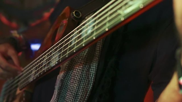 Cool close up of hands of bass guitar player playing