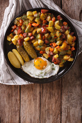 Finnish food pyttipannu: fried potatoes with sausages, eggs and pickled. vertical top view
