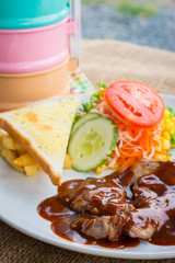 Beef steak with black pepper sauce , salad and French fries on s
