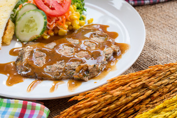 Beef steak with black pepper sauce , salad and French fries on s